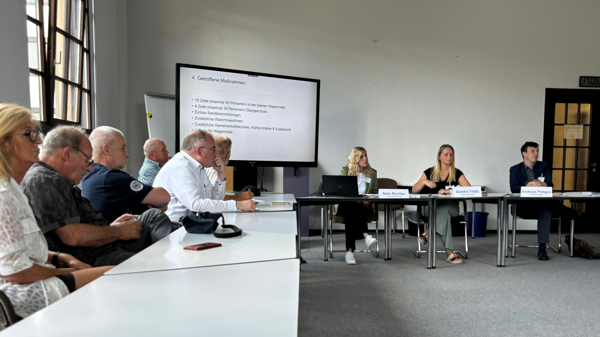 Auf dem Bild sind Personen an Tischen im Rathaus zu sehen, die eine Infoveranstaltung besuchen.