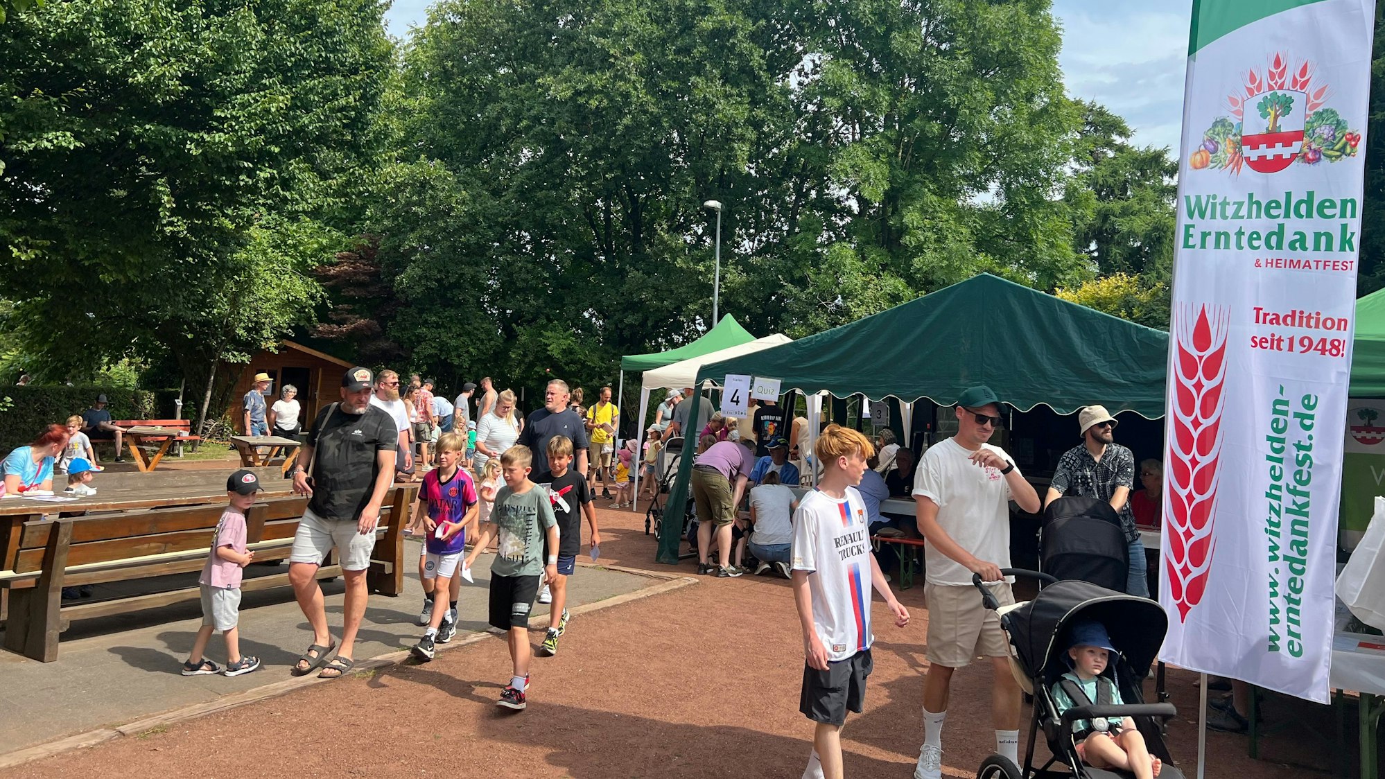 Menschen laufen über eine Festgelände.