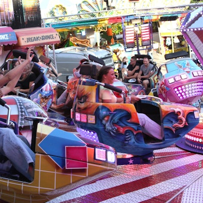 Auf dem Bild sind Kirmesbesucher in einem bunten Fahrgeschäft zu sehen.