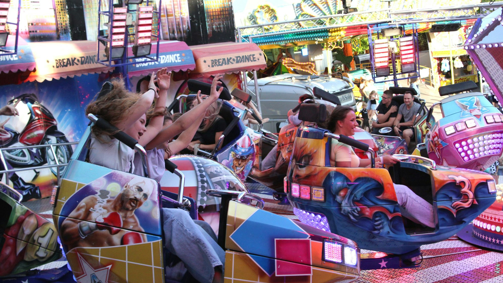 Auf dem Bild sind Kirmesbesucher in einem bunten Fahrgeschäft zu sehen.