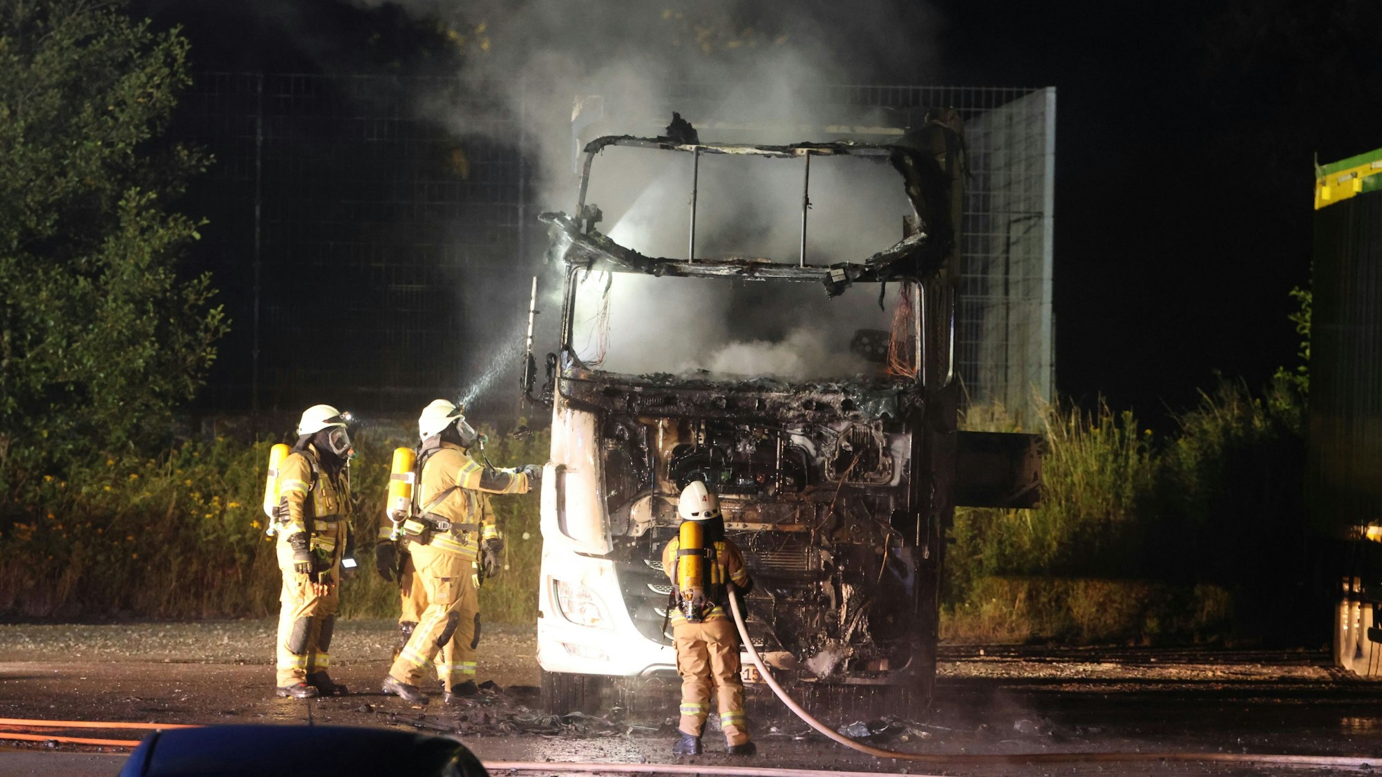 Das Foto zeigt Feuerwehrleute, die einen brennenden Lkw löschen.