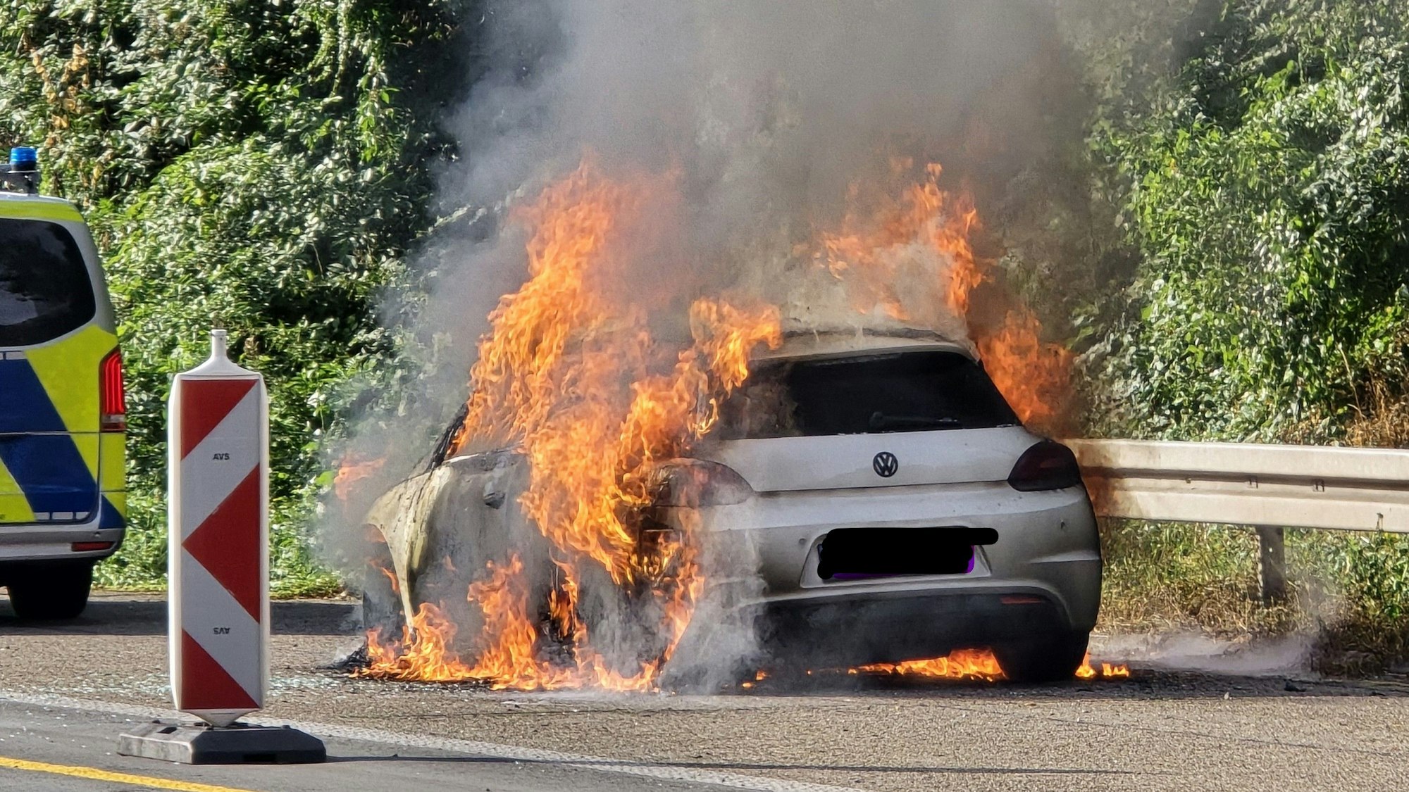 Ein brennendes Auto am Straßenrand