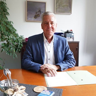 Das Foto zeigt einen Mann am Schreibtisch.