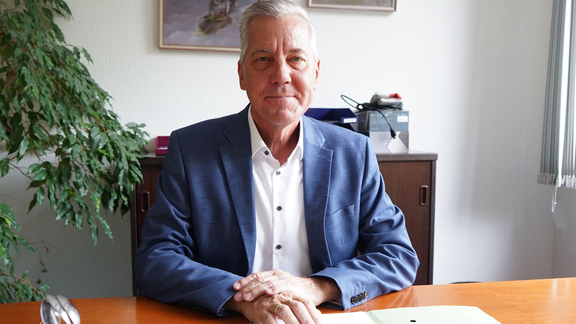 Das Foto zeigt einen Mann am Schreibtisch.