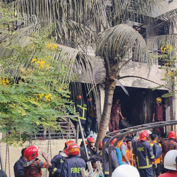 Feuerwehrleute untersuchen das Wrack eines Trainingsflugzeugs der Bangladesh Air Force, das auf ein Schulgelände abgestürzt ist.