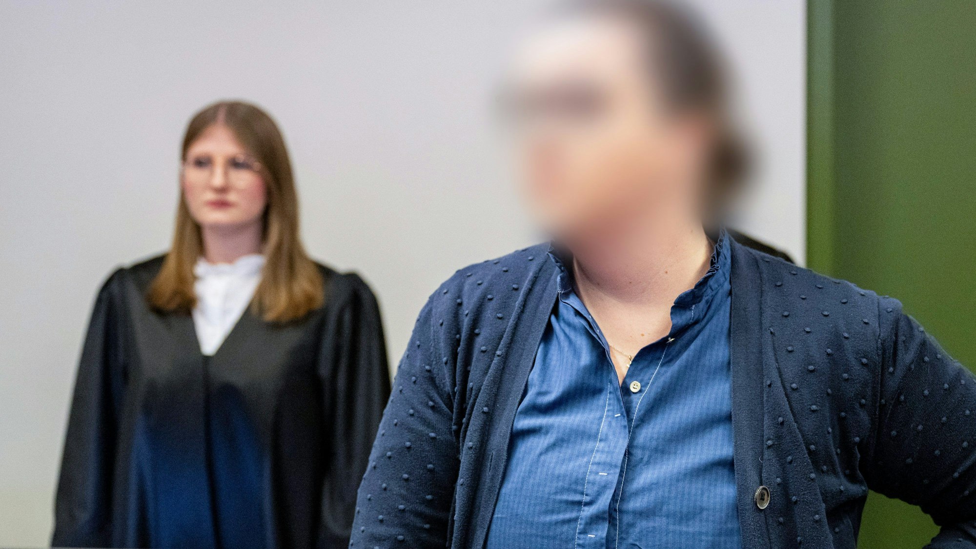 15.12.2023, Bayern, München: Die Angeklagte Andrea Tandler steht vor der Urteilsverkündung im Gerichtssaal des Landgerichts. Die Politikertochter und Unternehmerin Andrea Tandler muss in der Affäre um Corona-Schutzmasken wegen Steuerhinterziehung für vier Jahre und fünf Monate in Haft. Dieses Urteil verkündete das Landgericht München I am Freitag. Ihr mitangeklagter Geschäftspartner N. wurde zu drei Jahren und neun Monaten Haft verurteilt. Foto: Lennart Preiss/dpa - ACHTUNG: Person wurde aus rechtlichen Gründen gepixelt +++ dpa-Bildfunk +++