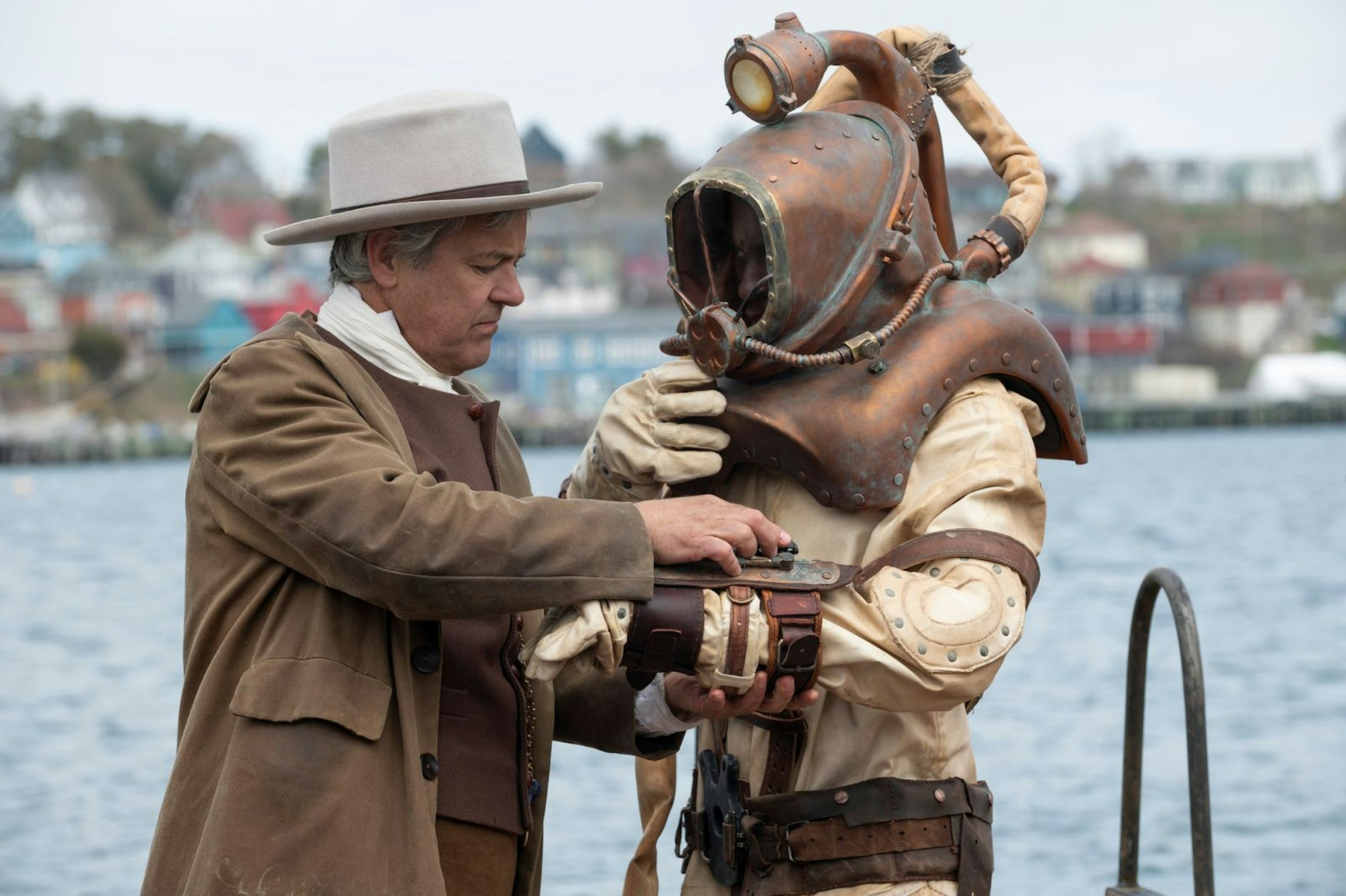 Tannas Vater (Rupert Graves, links), ein weißer Engländer und Neuankömmling in Halifax, bereitet George Washington (Ernest Kingsley Junior) auf einen Tauchgang vor. (Bild: Disney/Chris Reardon)