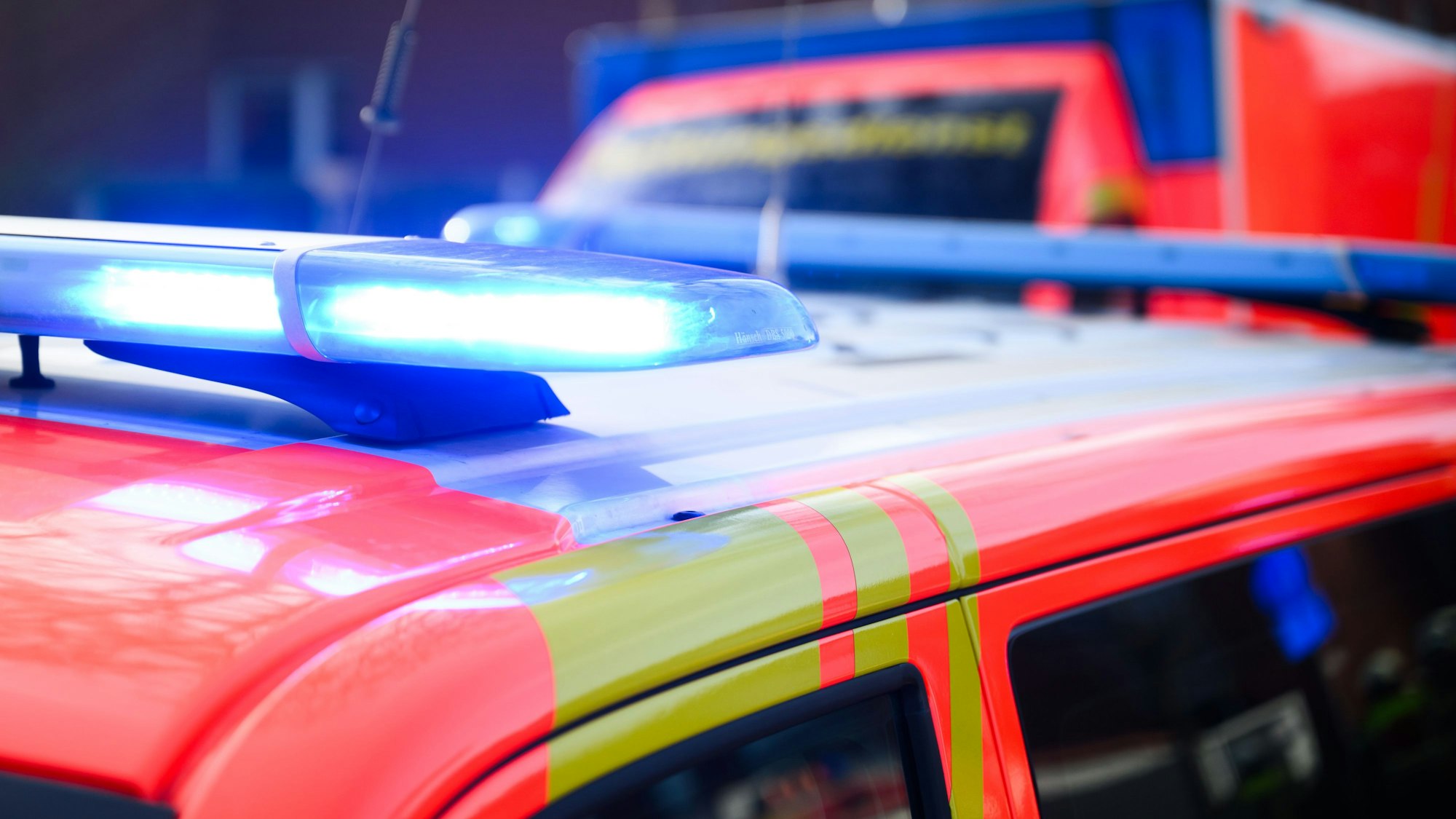 Blaulichter leuchten an einer Einsatzstelle auf einem Notarzt Fahrzeug und einem Rettungswagen.