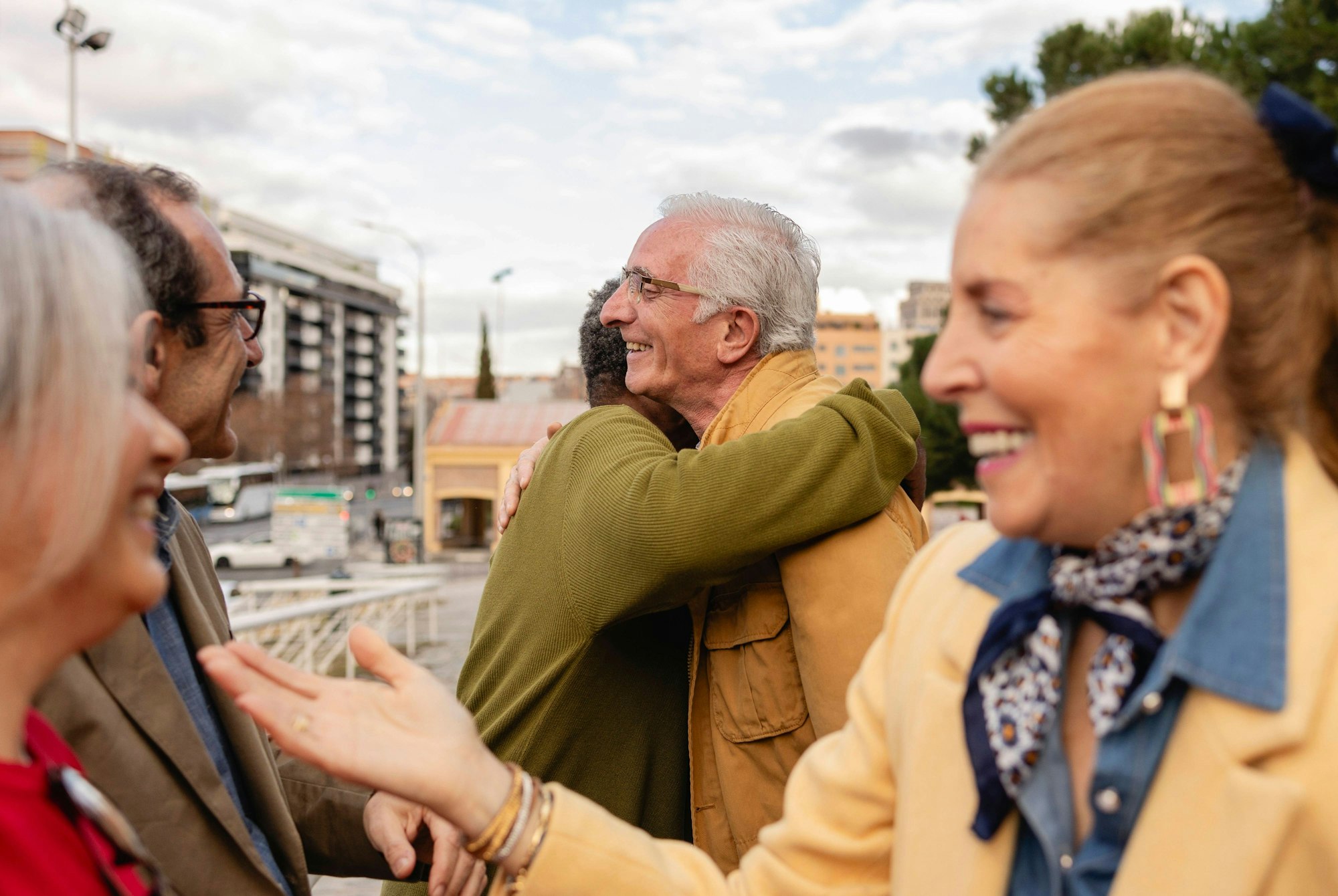 Senior friends socializing and hugging outdoors in an urban setting model released, Symbolfoto, JCCMF12883
