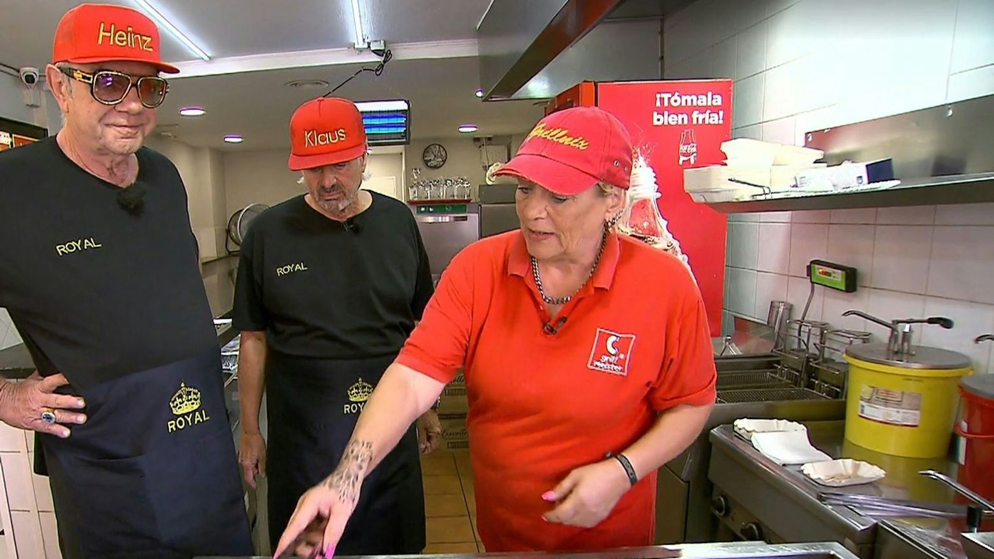 Imbiss-Expertin Chris weist Heinz (links) und Klaus in die Kunst des Würstchen-Bratens ein. (Bild: VOX)