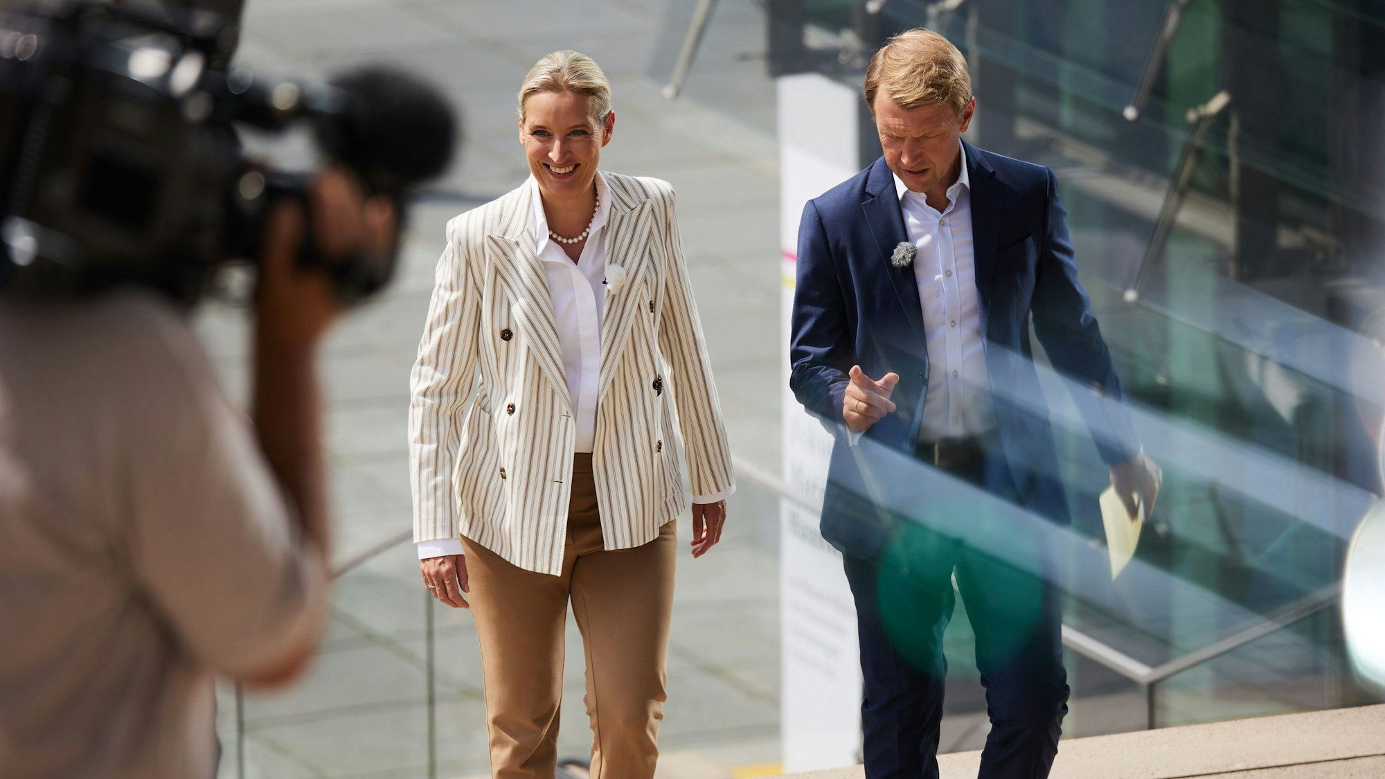 Das Bild zeigt Alice Weidel (AfD), Parteivorsitzende, und Moderator Markus Preiß auf dem Weg zum ARD-Sommerinterview. Foto: Jörg Carstensen/dpa