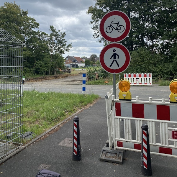 Auf dem Bild ist eine Absperrung mit Barken und Schildern zu sehen.