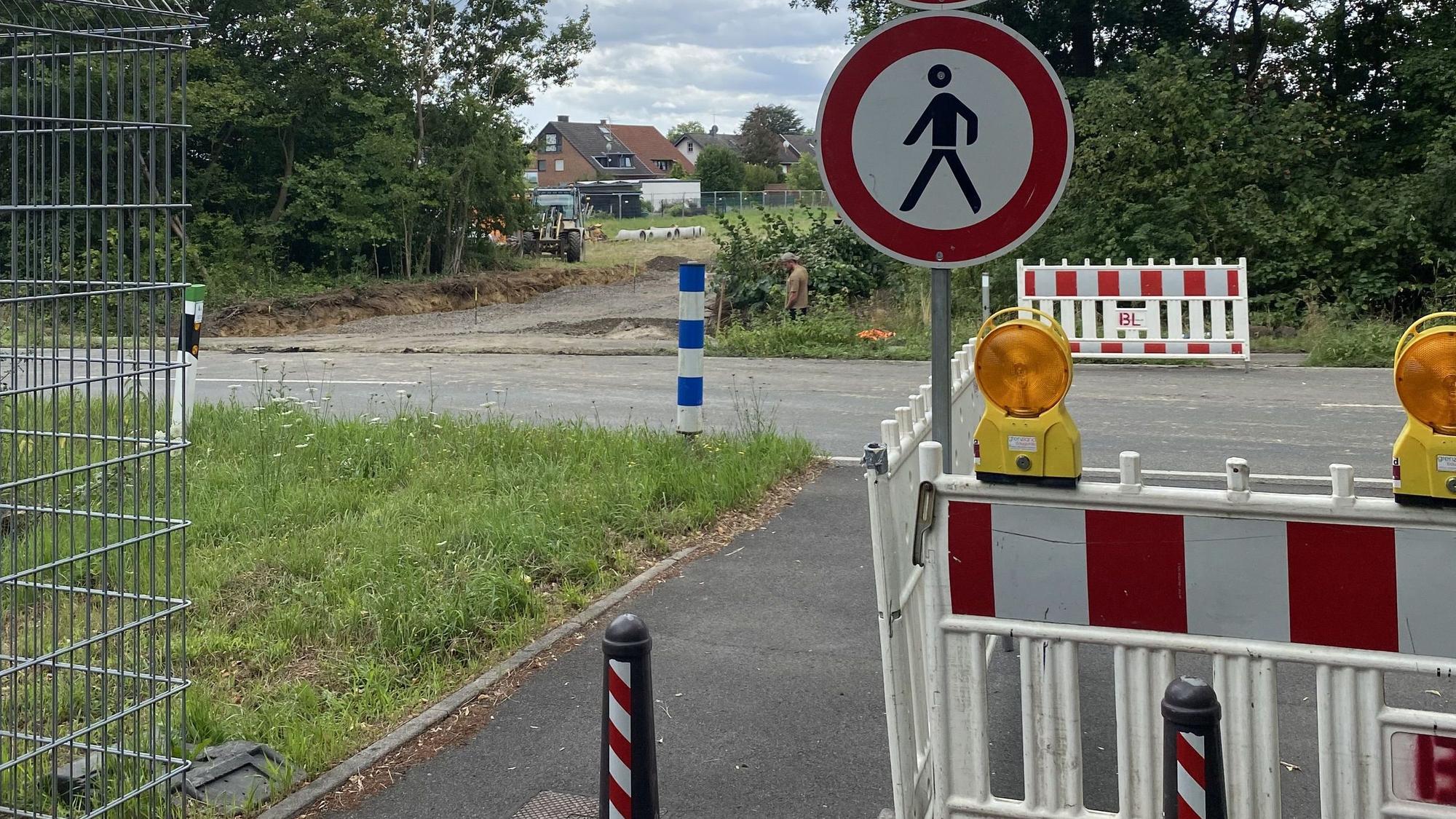 Auf dem Bild ist eine Absperrung mit Barken und Schildern zu sehen.