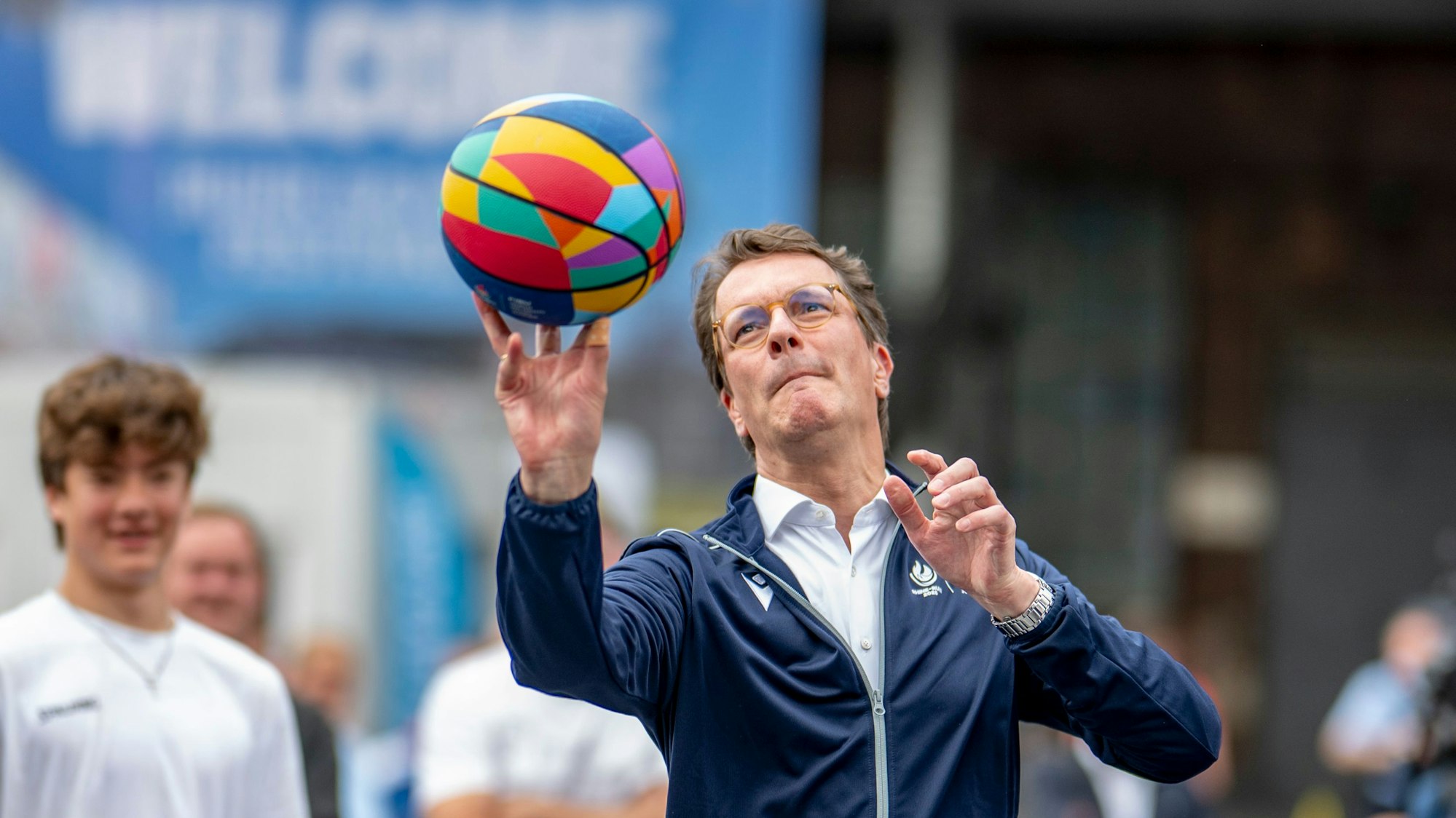 Hendrik Wüst (CDU), Ministerpräsident von Nordrhein-Westfalen, wirft bei der Eröffnung der Wettkampfstätte an der Jahrhunderthalle einen Basketball auf den Korb.