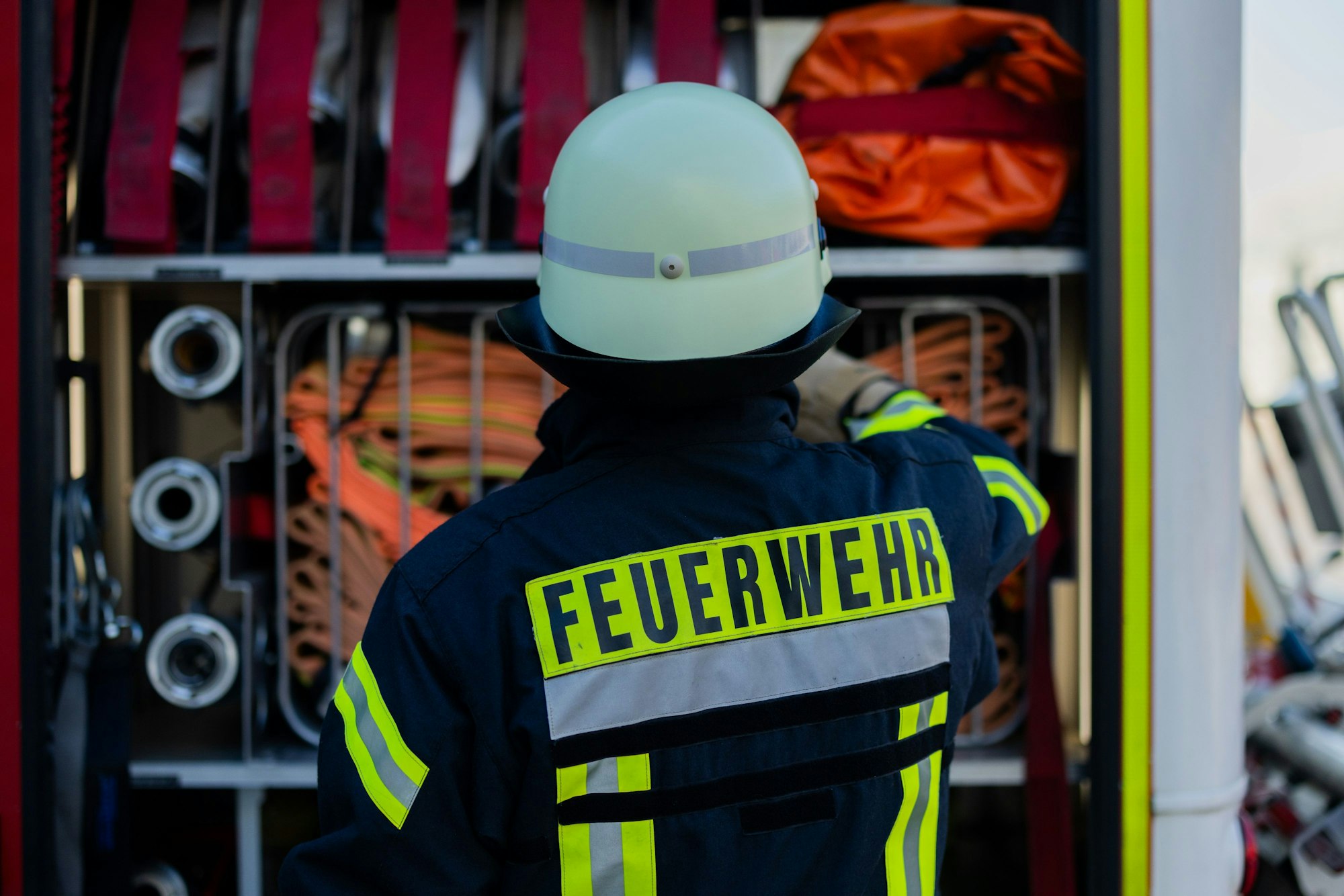 Ein Feuerwehrmann holt Equipment aus einem Einsatzfahrzeug.