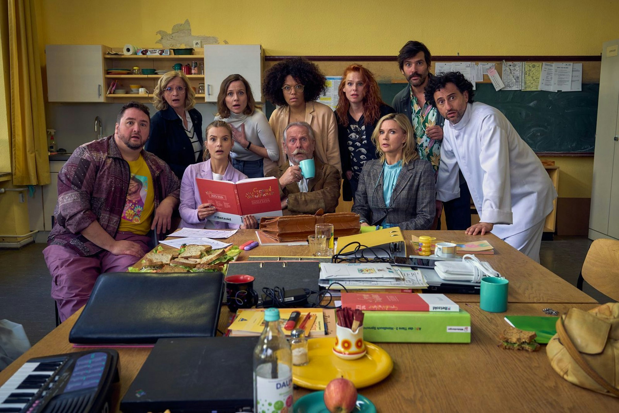 Die hoch gelobte Impro-Serie „Andere Eltern“ über eine Kita-Gründung geht einige Jahre später als Film und in der Grundschule weiter. Das Ensemble des ZDF-Films umfasst unerwartete Stars wie Veronica Ferres (dritte von rechts) als Direktorin oder Ex-Höhner-Sänger Henning Krautmacher (Mitte, vorn). (Bild: ZDF und © Frank Dicks)