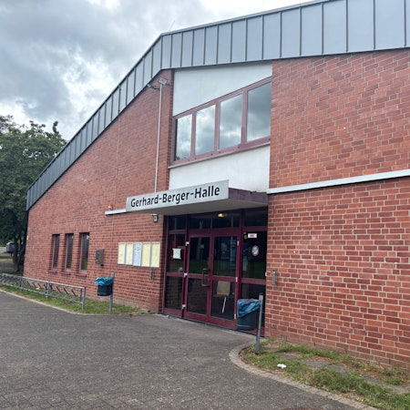 Auf dem Bild ist der Haupteingang einer Sporthalle zu sehen.