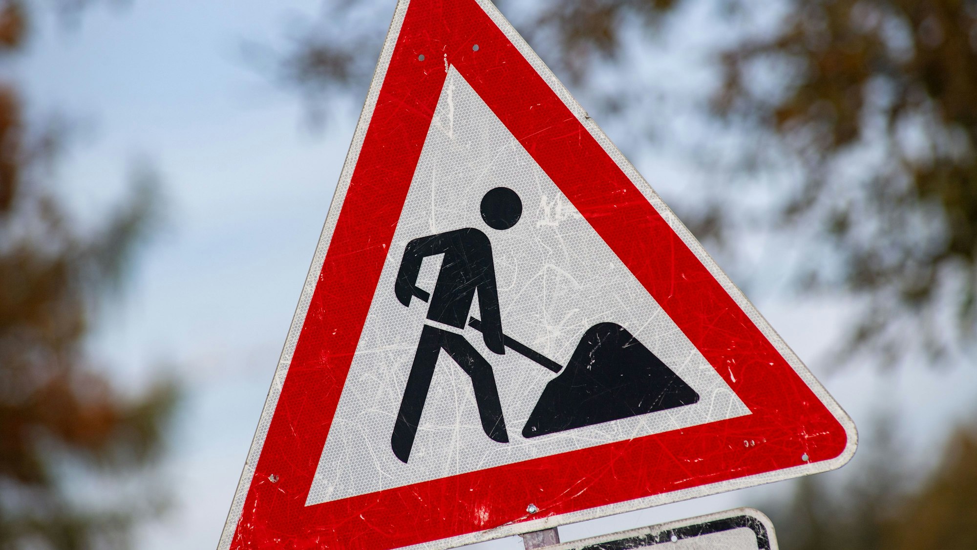 .Ein Baustellen-Schild steht vor einer Baustelle
