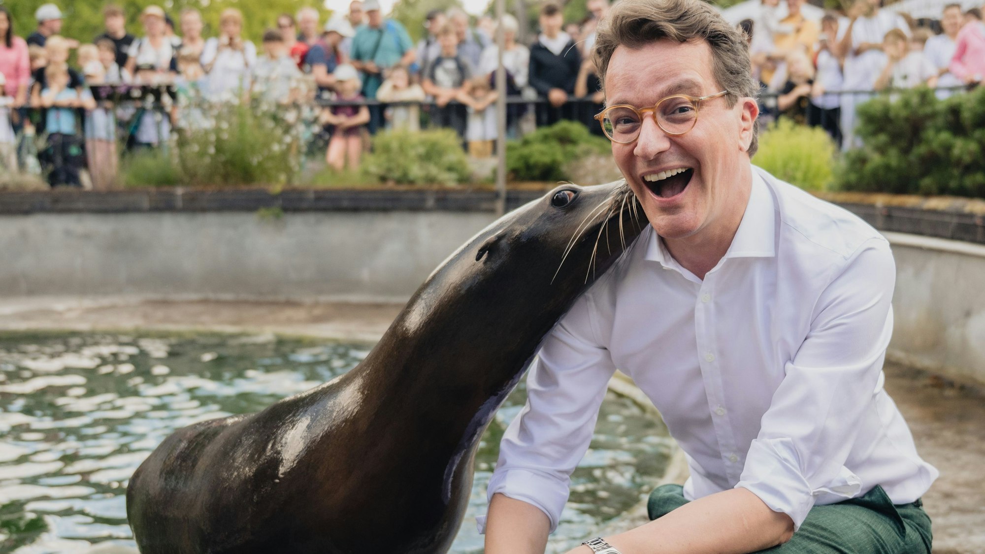 MP Hendrik Wüst beim Besuch im Kölner Zoo. Eine Robbe gab ihm einen feuchten Kuss.