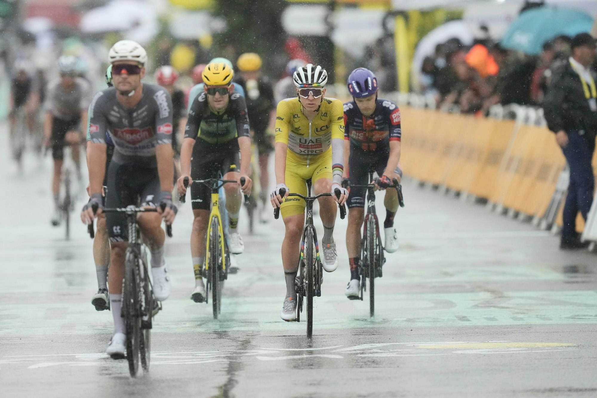 Der Tour-Führende Tadej Pogacar kommt bei Regen ins Ziel.