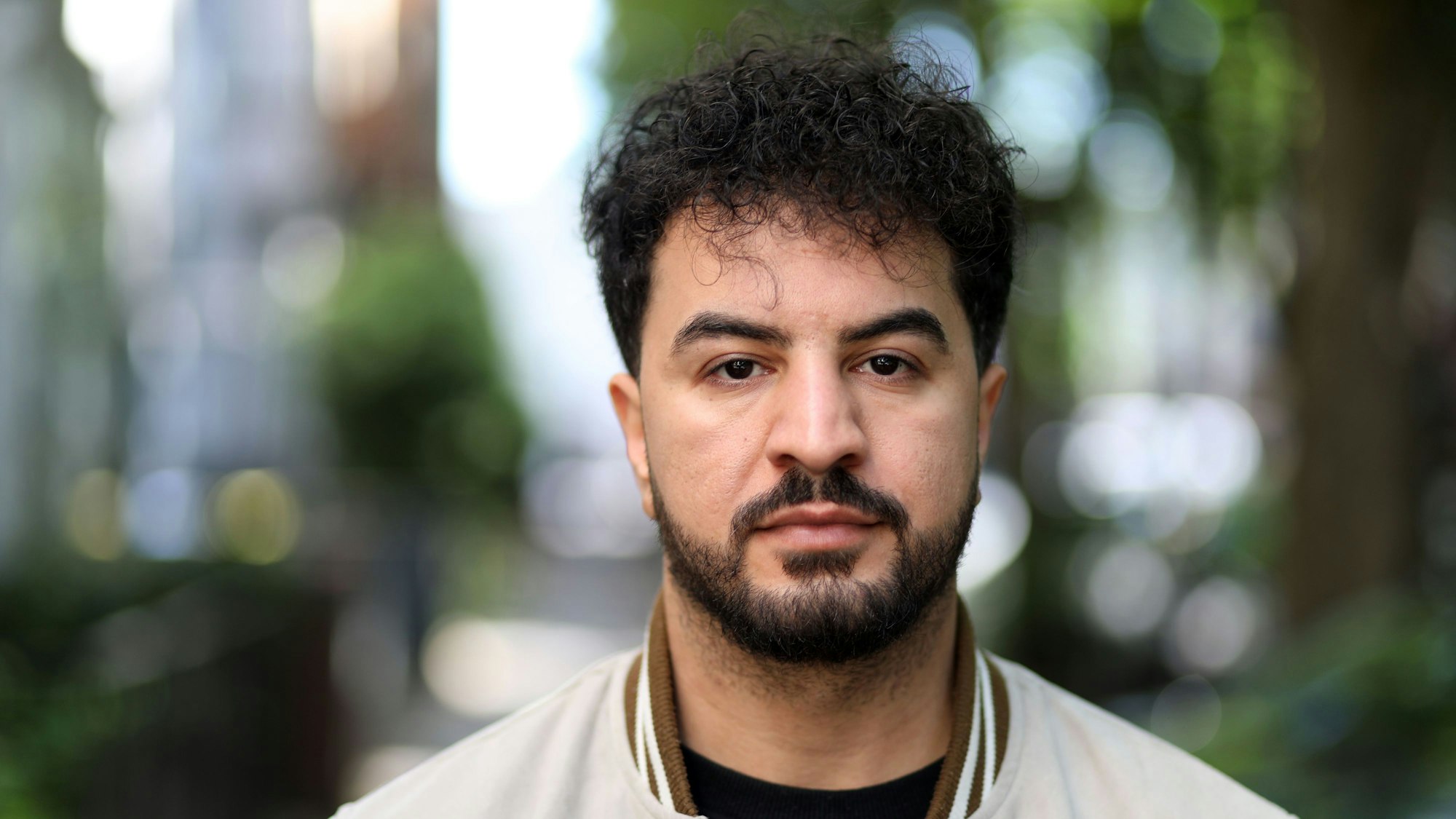 Ali AL-Qoshachee blickt für ein Porträtfoto in die Kamera