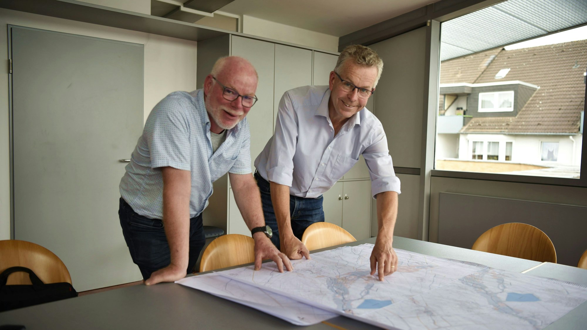 22.07.2025 Zülpich. Jürgen Kremer und Dr. Peter Kramp stehen an einem Tisch und beugen sich über ein Starkregenkarte.