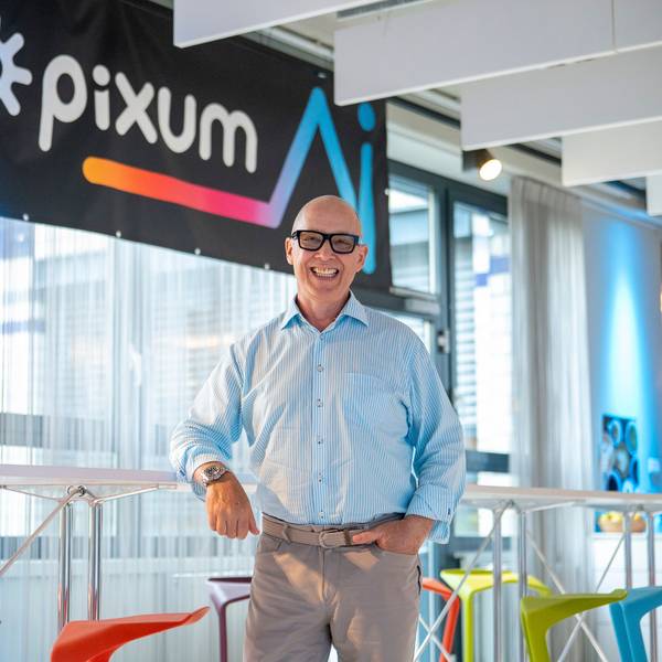 Daniel Attallah steht vor einem Pixum-Logo
