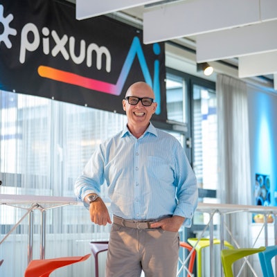 Daniel Attallah steht vor einem Pixum-Logo