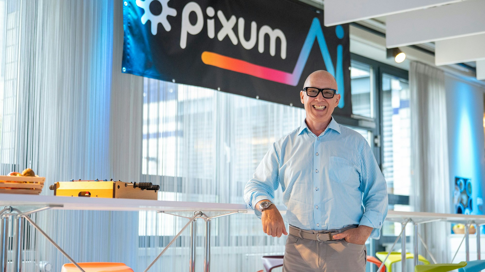 Daniel Attallah steht vor einem Pixum-Logo