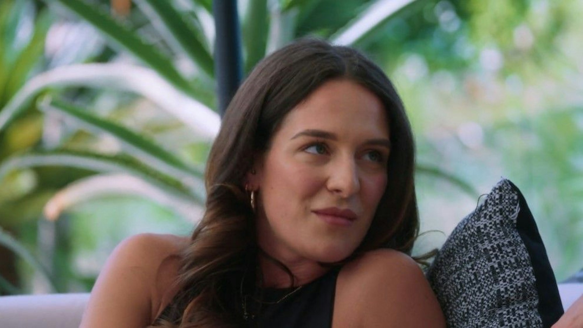 Kandidatin Leonie sitzt auf einem Sofa, schaut nach rechts.