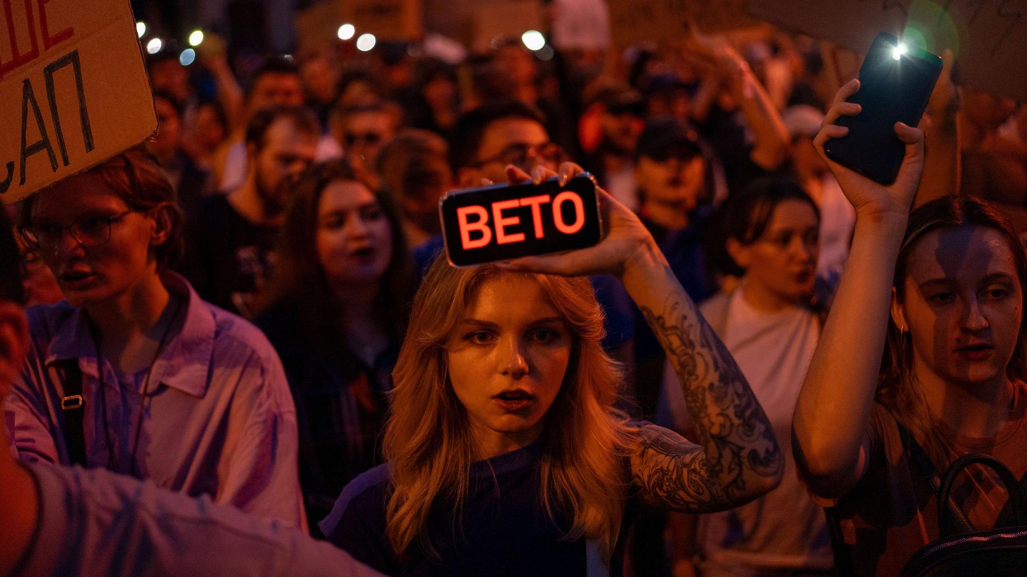 22.07.2025, Ukraine, Kiew: Eine Frau hält während des Protests gegen ein Gesetz, das die Unabhängigkeit von Organen zur Korruptionsbekämpfung beschränkt, ein Telefon mit der Aufschrift „Veto“. Foto: Alex Babenko/AP/dpa +++ dpa-Bildfunk +++