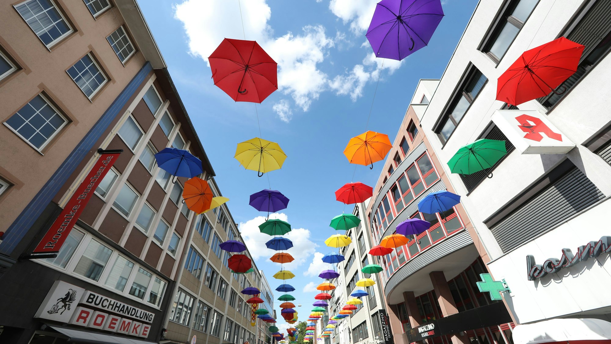 23.07.2025, Köln: Bunte Regenschirme hängen an der Apostelnstraße. In den Nächsten Tagen wird es viel regnen. Foto: Arton Krasniqi