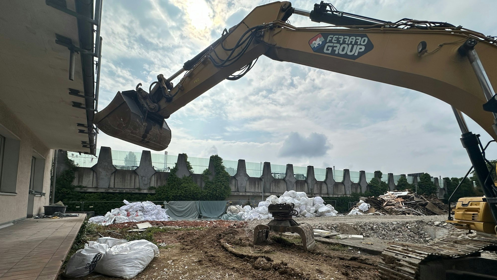 Die Rückansicht der hellen Mietshäuser. Der Bagger wartet auf seinen Einsatz. Rechts sind die Häuser auf den Grundstücken schon niedergelegt worden.