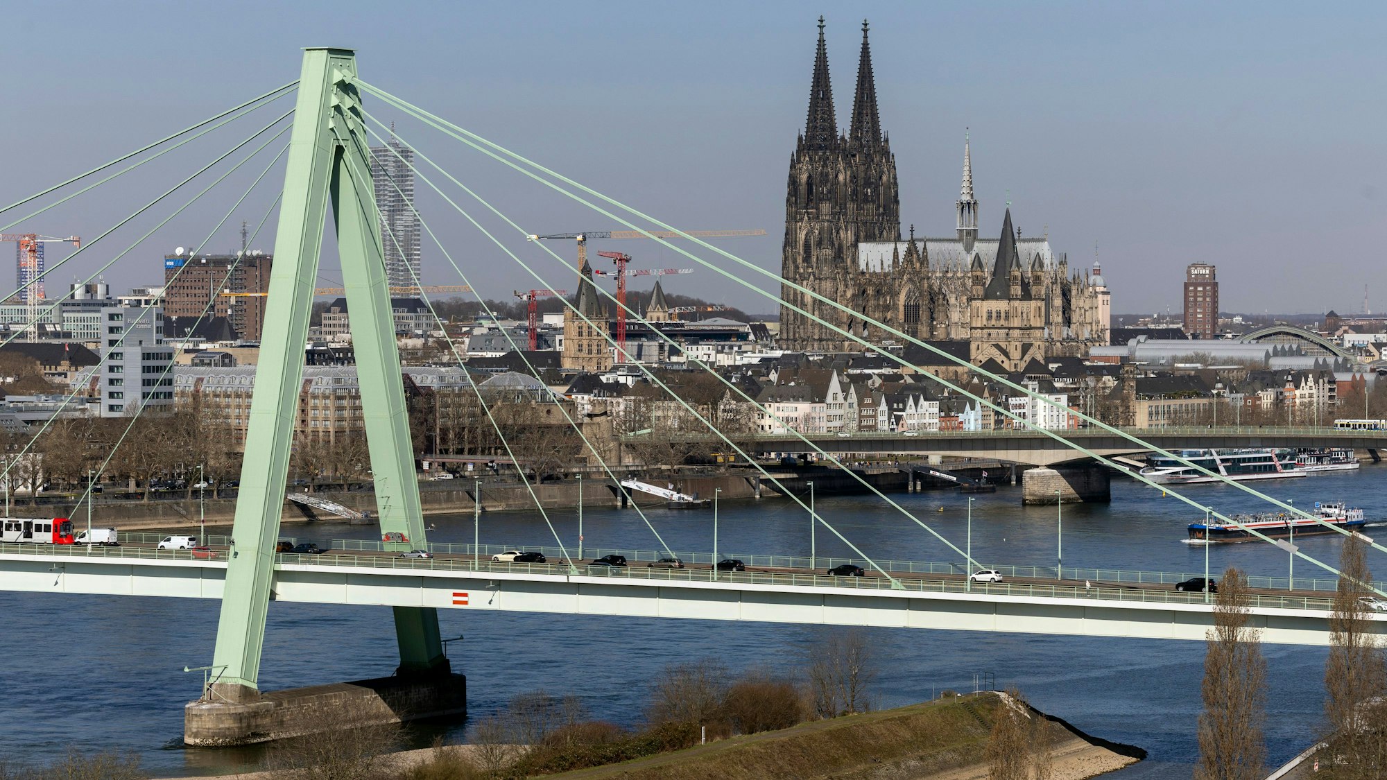 19.03.2025, Köln: Stadtansichten gesehen von der Auermühle am Deutzer Hafen.
Im Bild Blick auf die Severinsbrücke mit dem Eingang zum Deutzer Hafen und Drehbrücke im Vordergrund und dem Dom und Rhein im Hintergrund.
Foto: Michael Bause