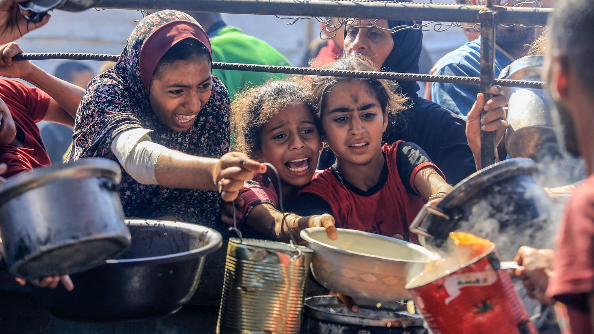 Palästinensische Kinder versuchen sich bei einer Ausgabestelle für Hilfslieferungen Nahrung zu sichern. Die humanitäre Lage im Gazastreifen hat sich drastisch verschärft. (Archivbild)