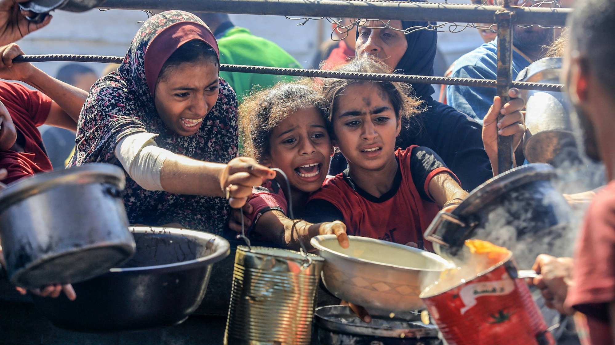 Palästinensische Kinder versuchen sich bei einer Ausgabestelle für Hilfslieferungen Nahrung zu sichern. Die humanitäre Lage im Gazastreifen hat sich drastisch verschärft. (Archivbild)