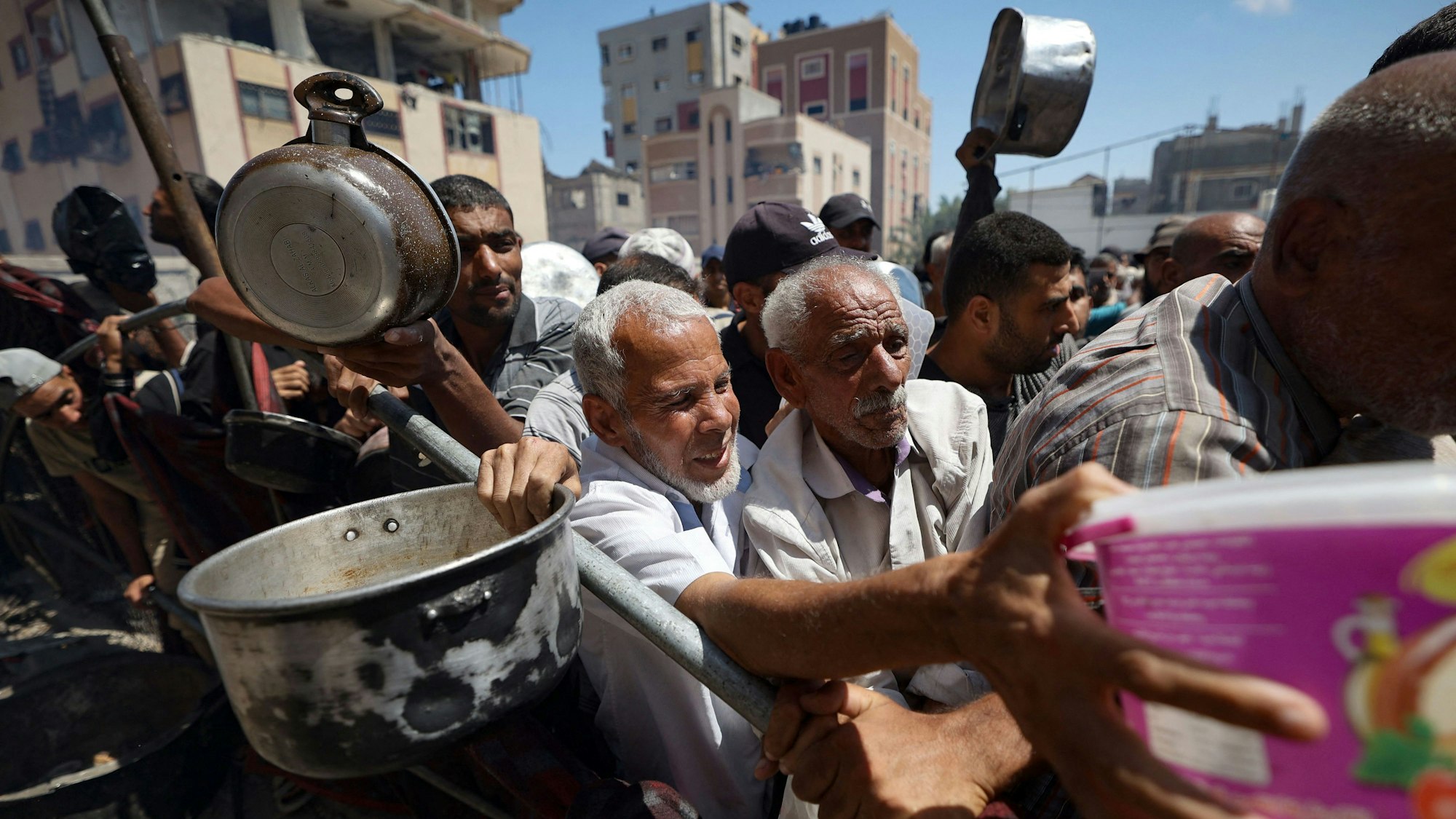 Palästinenser versammeln sich an einer Ausgabestelle für Hilfspakete. Die Lage im Gazastreifen wird von Hilfsorganisationen als katastrophal beschrieben. (Archivbild)