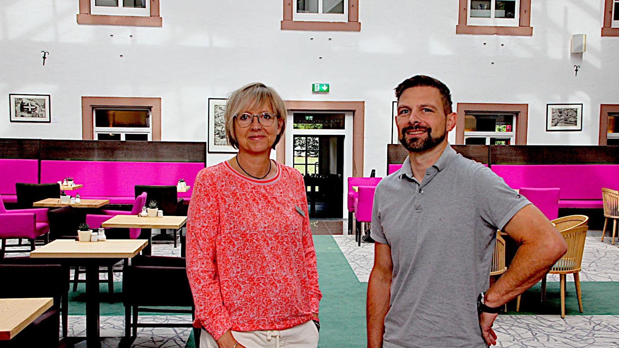 Die beiden Hoteliers vor den Tischen im Innenhof des Restaurants im Hillesheimer Augustinerkloster.