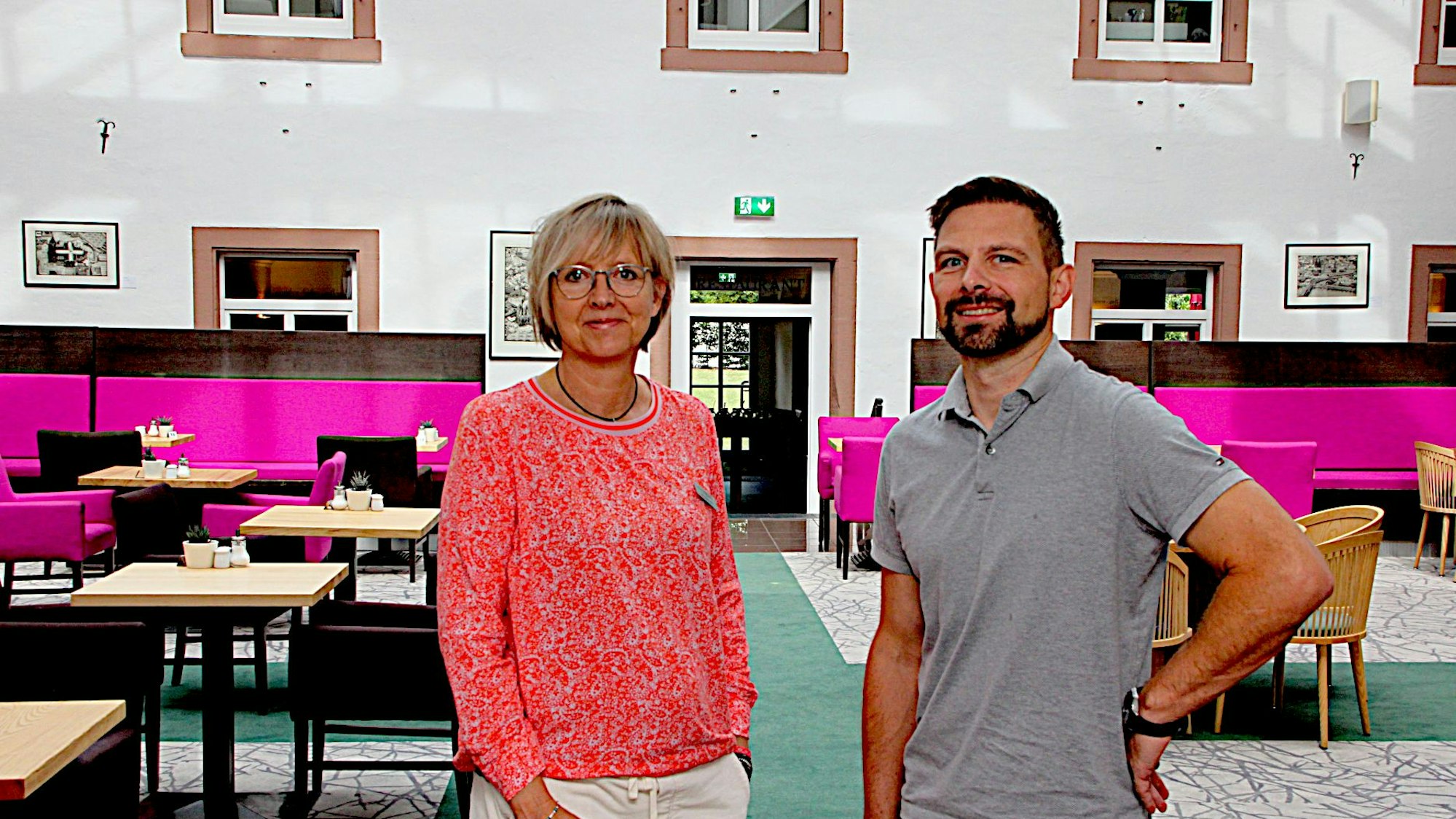 Die beiden Hoteliers vor den Tischen im Innenhof des Restaurants im Hillesheimer Augustinerkloster.