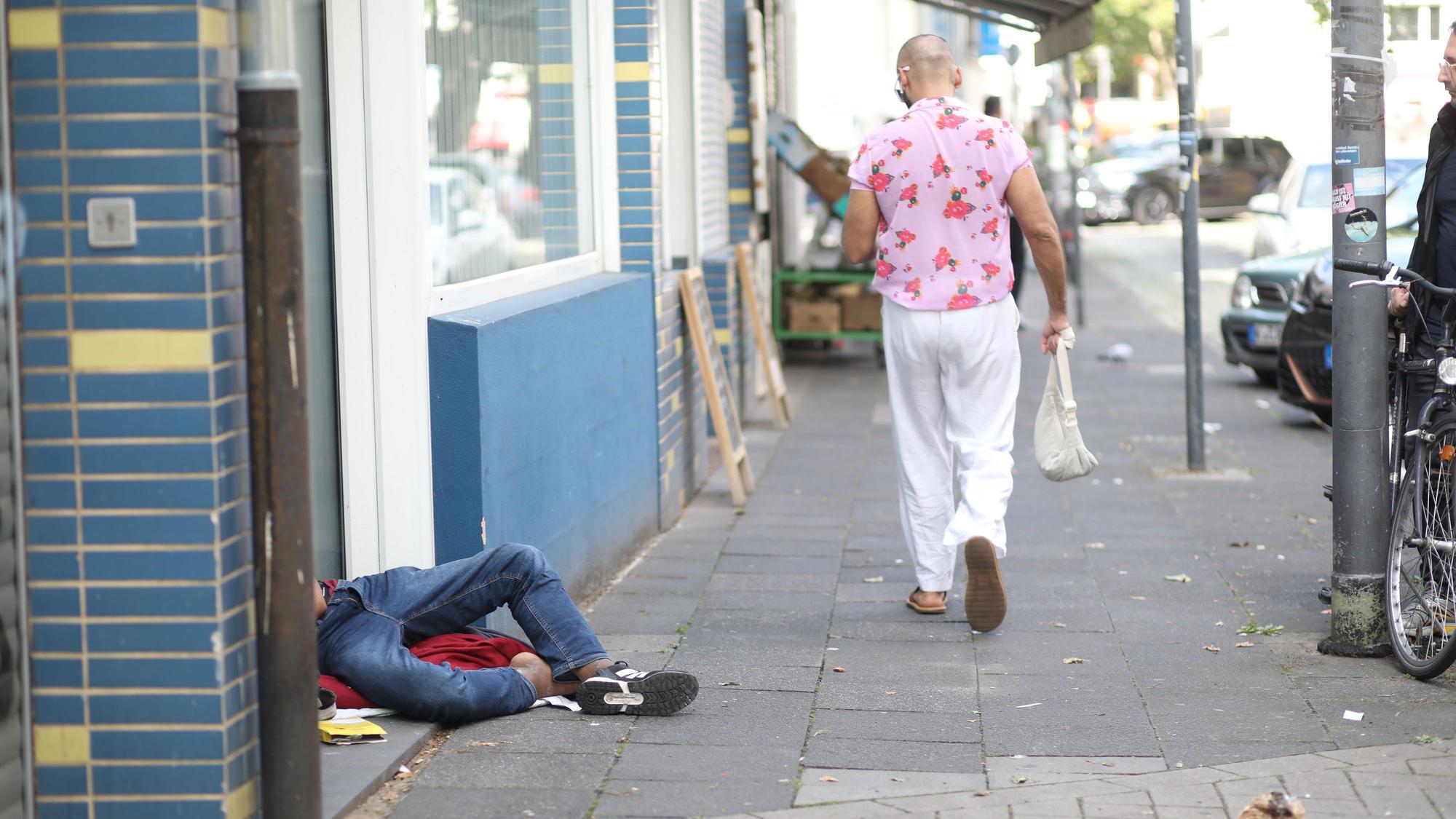 Ein Drogenabhängiger schläft sein Rausch vor einem Hauseingang aus. Zahlreiche Drogenabhängige prägen das Bild rund um den Neumarkt.