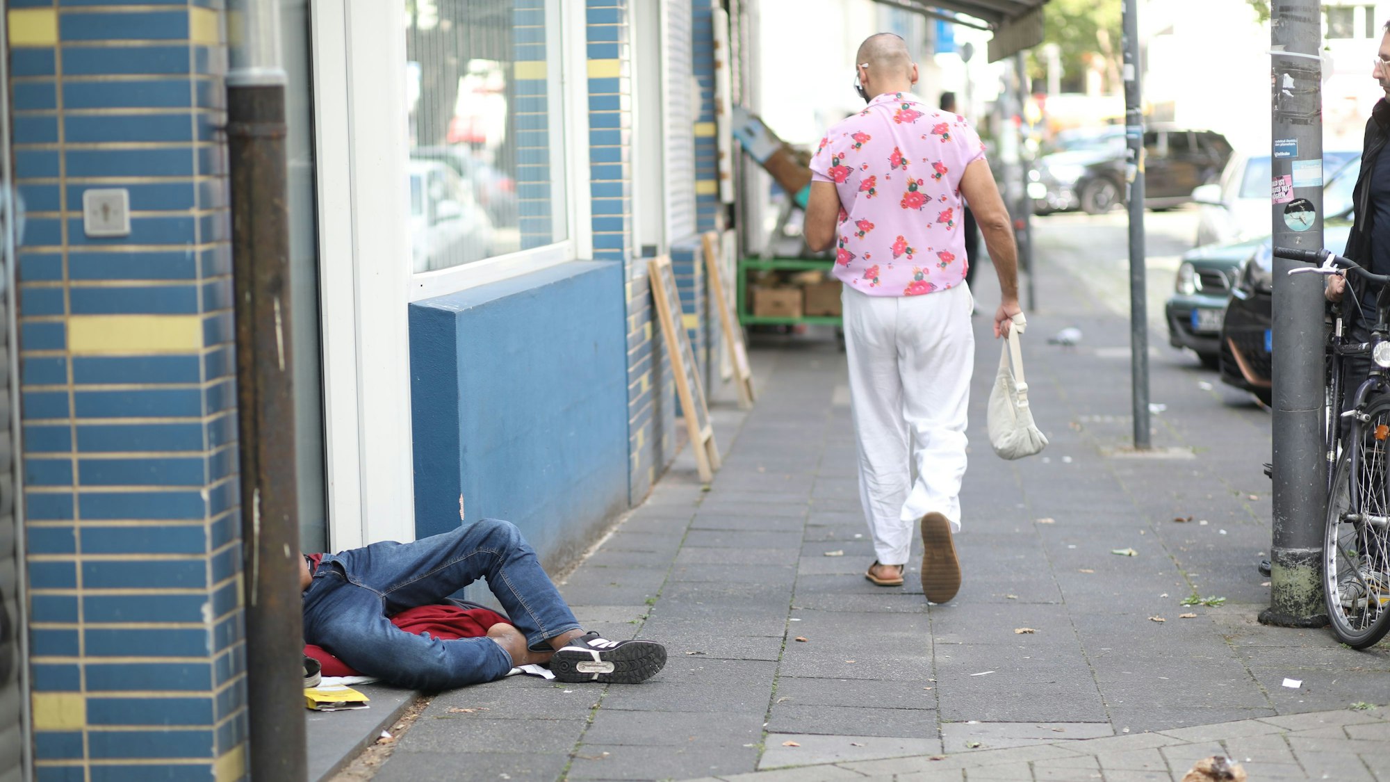 Ein Drogenabhängiger schläft sein Rausch vor einem Hauseingang aus. Zahlreiche Drogenabhängige prägen das Bild rund um den Neumarkt.