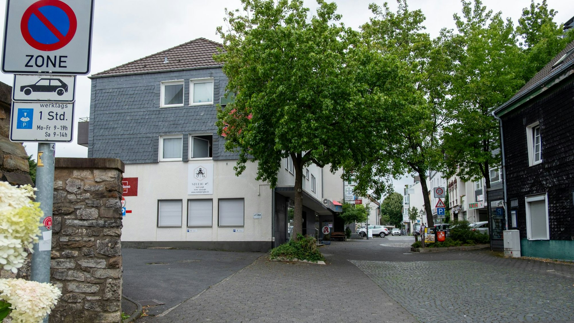 Im neuen Gebäude, vor dem ein paar Bäume stehen, befindet sich eine Apotheke.