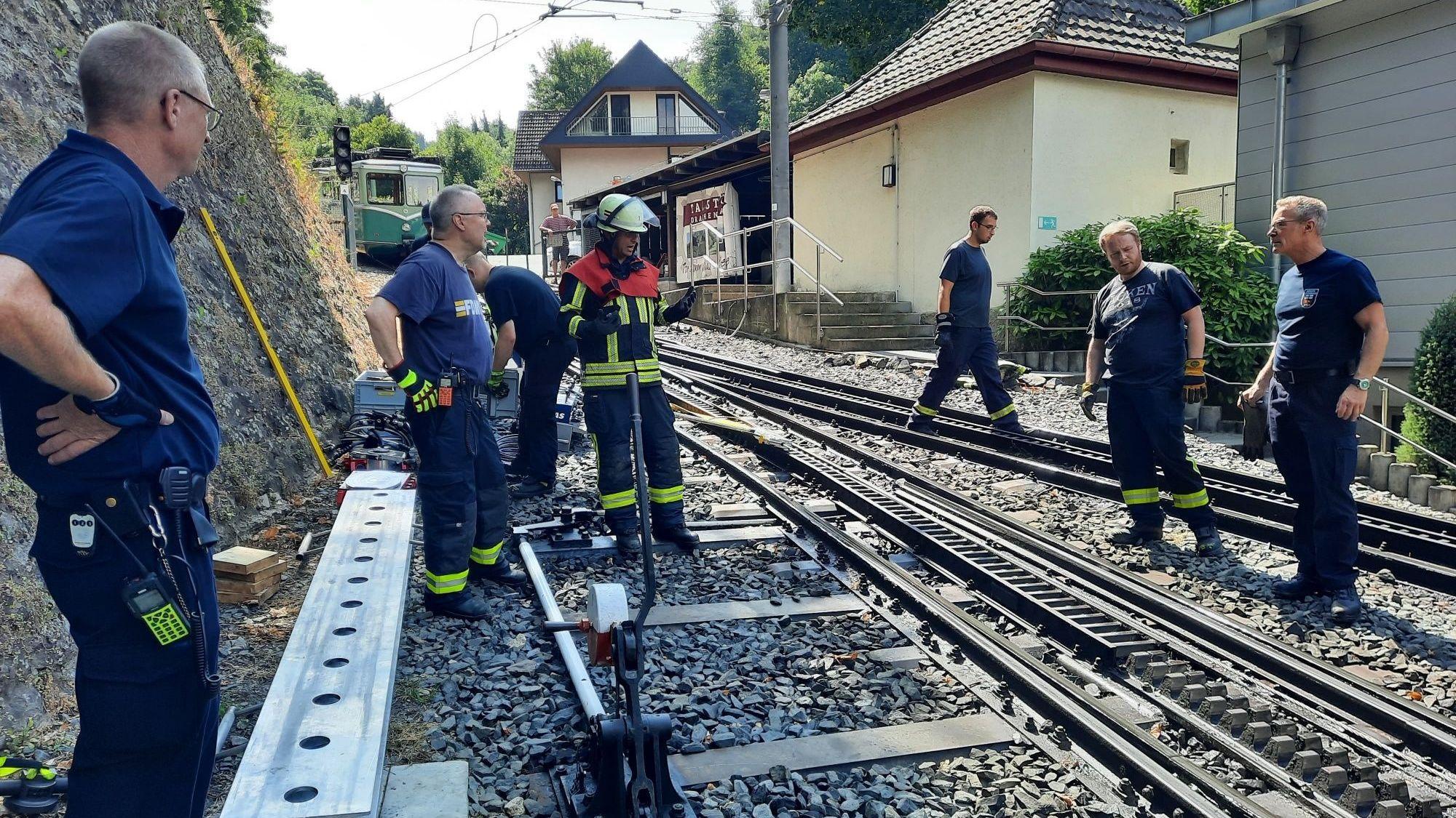 Feuerwehrleute auf den Gleisen der Drachenfelsbahn.