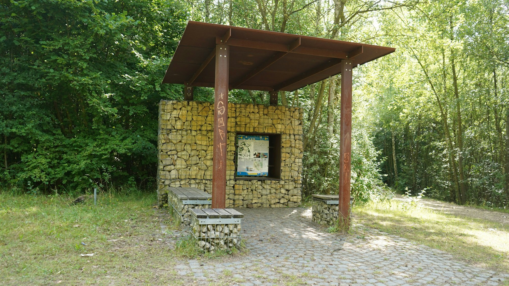 Das Foto zeigt einen Unterstand im Grünen.