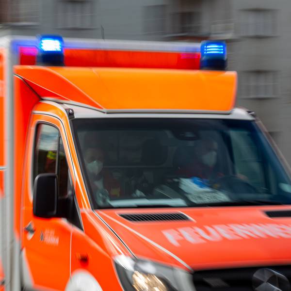 Ein Rettungswagen der Feuerwehr fährt auf einer Straße (Aufnahme mit Langzeitbelichtung).