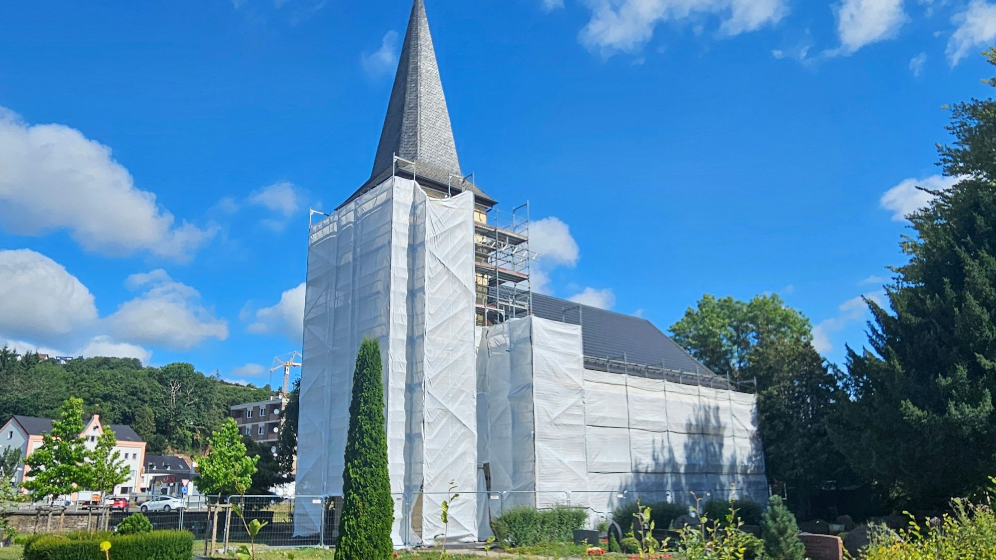 Turm und eine Seite der evangelischen Kirche in Schleiden sind mit Planen verhüllt.
