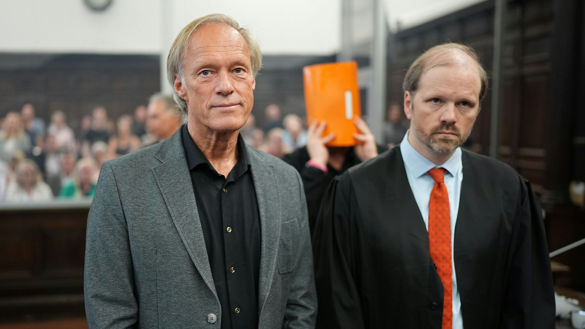 Gerhard Delling (l.), ehemaliger Fernsehmoderator und Sportjournalist, unterstürtzt seine Lebensgefährtin im Gerichtssaal.