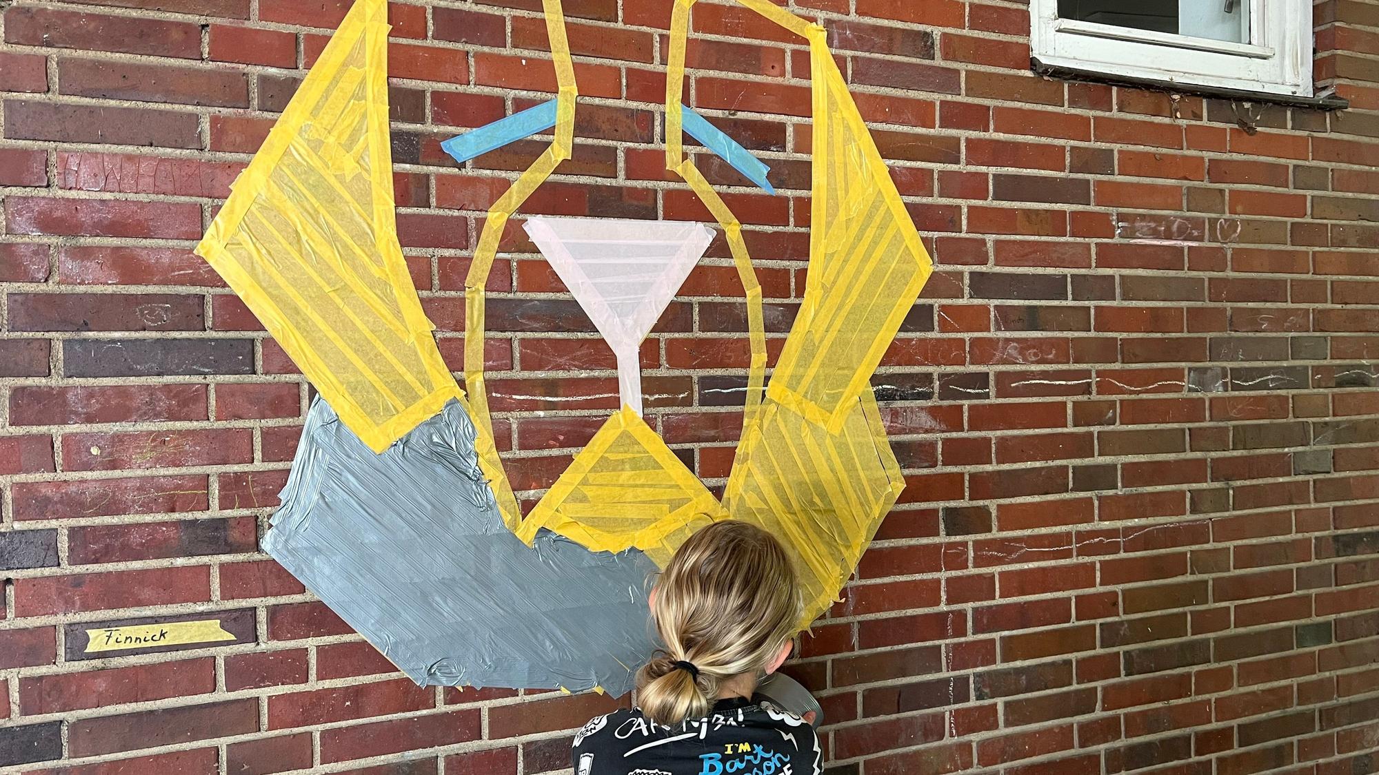 Finnick (12) klebt sein Motiv an die Wand