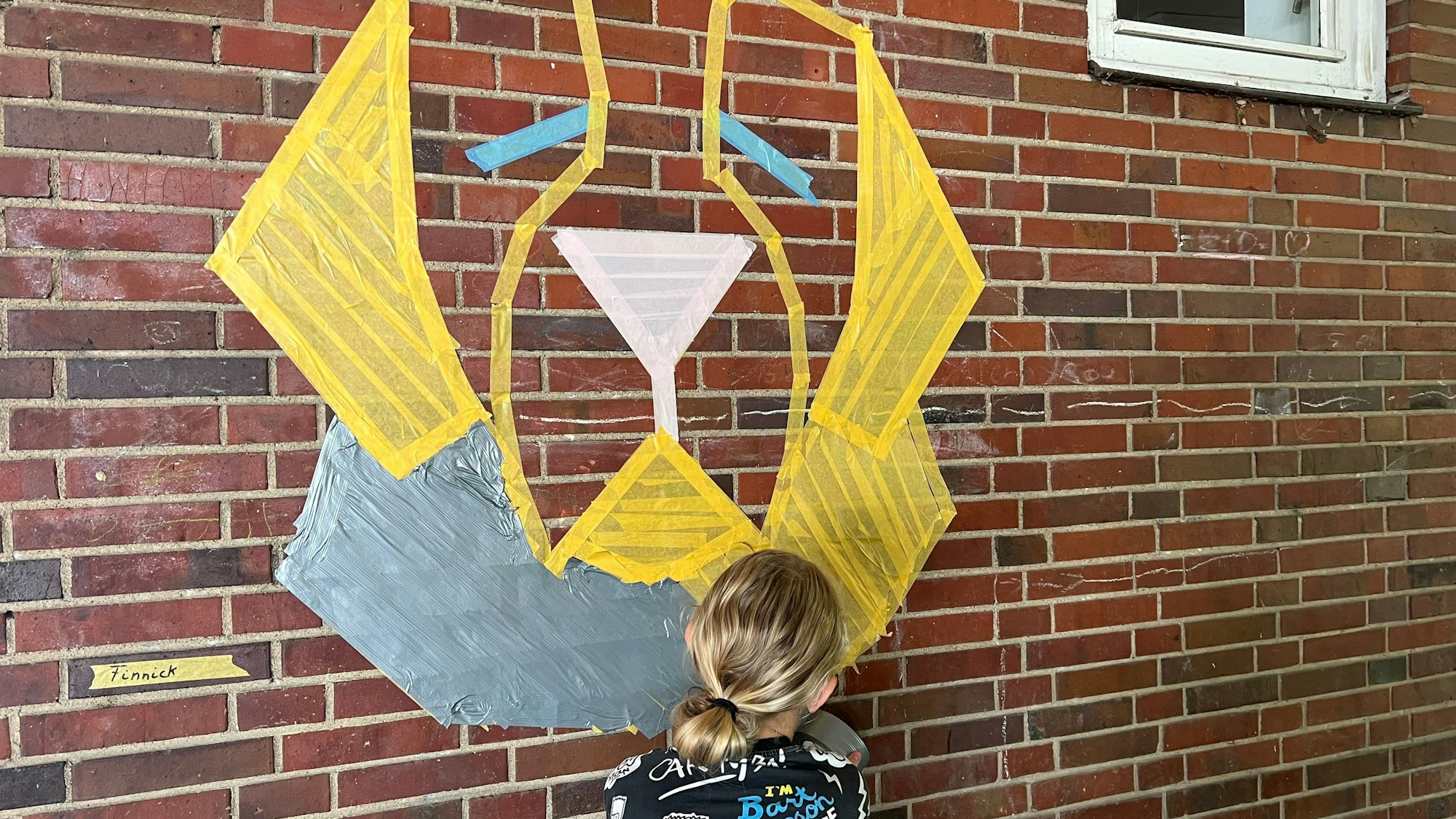 Finnick (12) klebt sein Motiv an die Wand