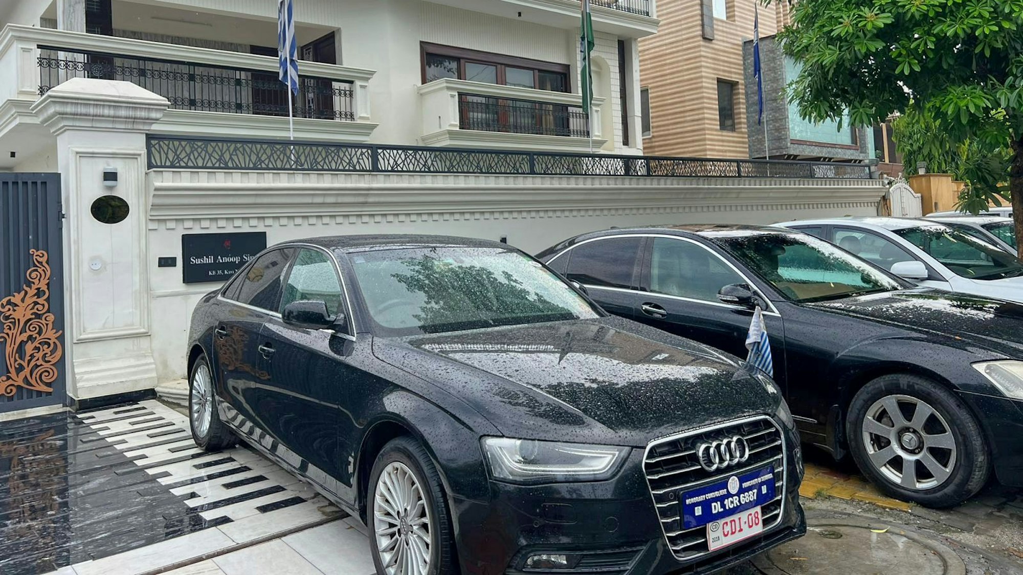 Luxusautos mit gefälschten diplomatischen Nummernschildern stehen vor einem gemieteten Wohnhaus, in dem eine Botschaft untergebracht war, die in Wirklichkeit nur zum Schein existierte.